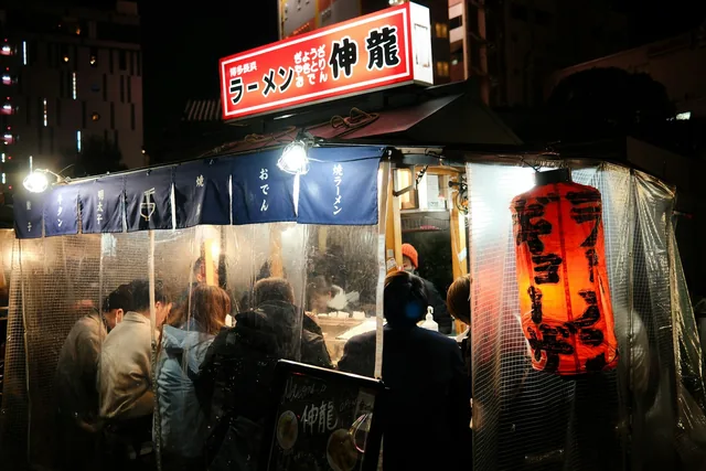 People waiting for food at a Japanese ramen stall