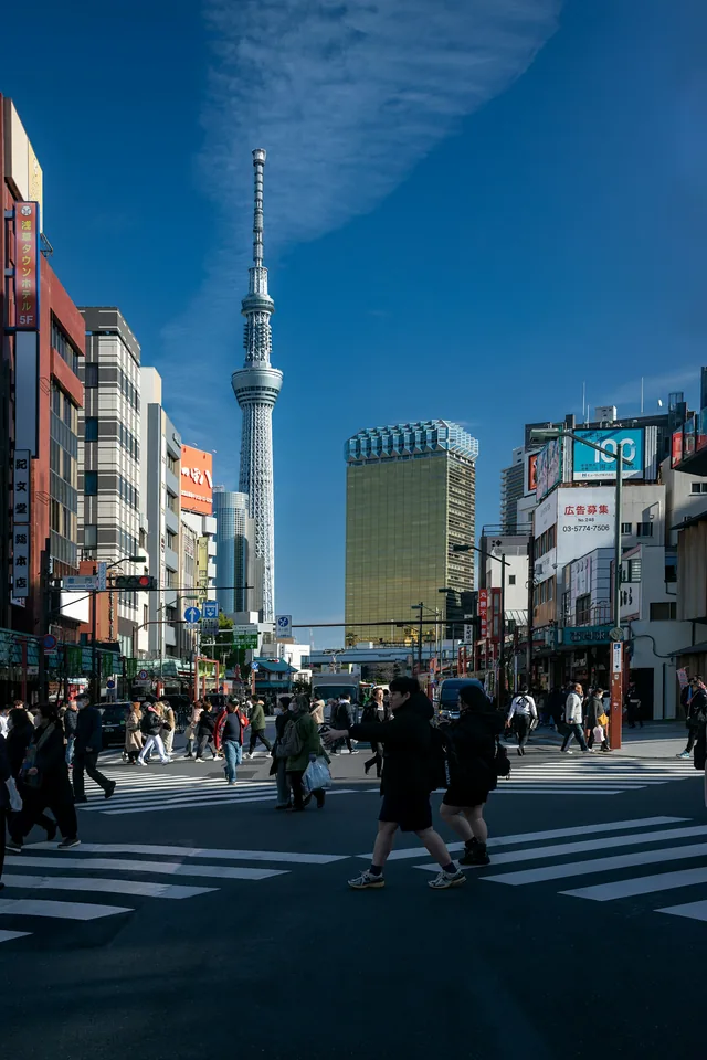 Street crossing in Asakusa, Tokyo, with Tokyo Skytree in the background.