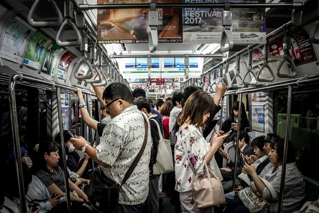 Real passengers using their phones inside a Tokyo train